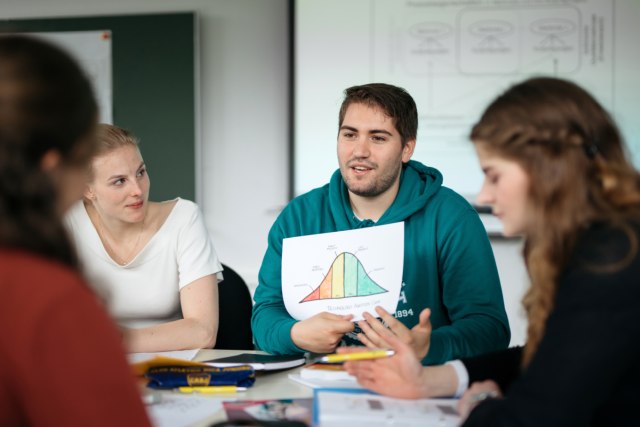 Studierende sitzen an einem Tisch und lernen