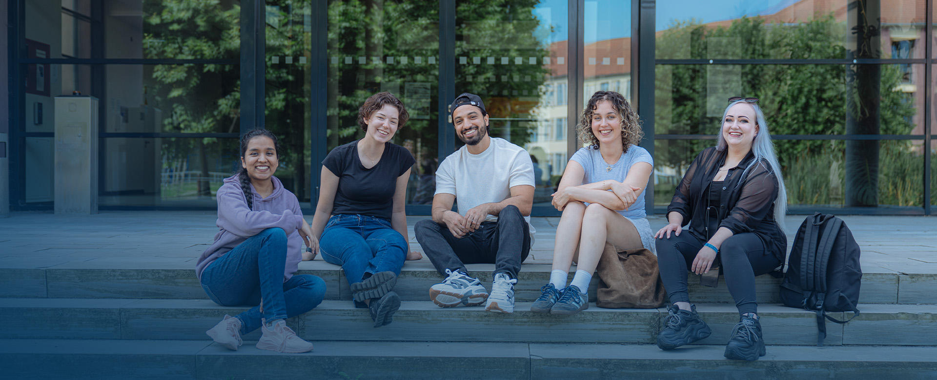 Studierende auf der Treppe vor dem Zusebau
