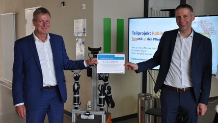 Staatssekretär und Präsident zeigen Zuweisungsbescheid
