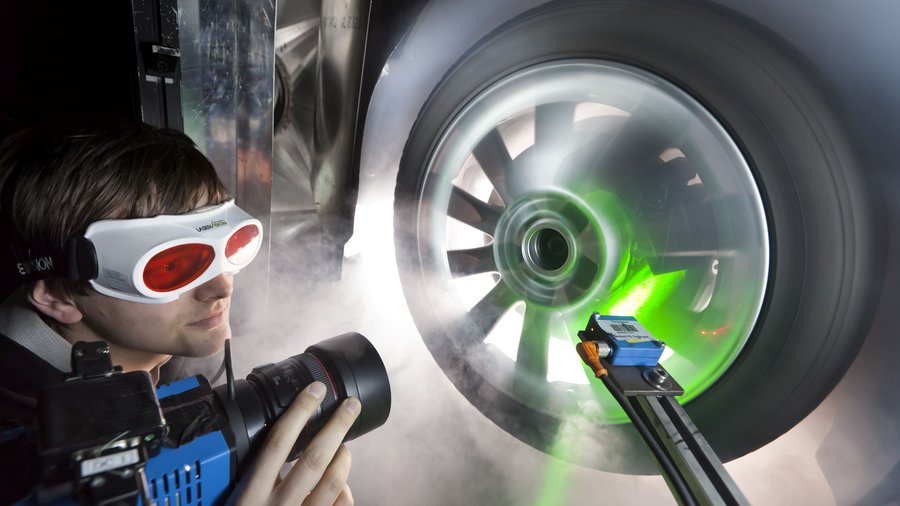 Mann mit Schutzbrille leuchtet Autorad an..