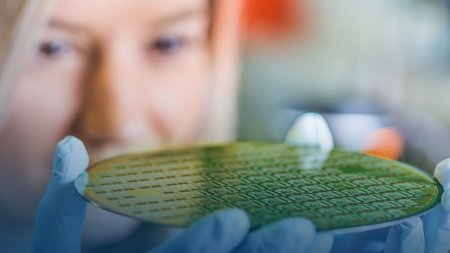 Wissenschaftlerin hält Wafer in der Hand