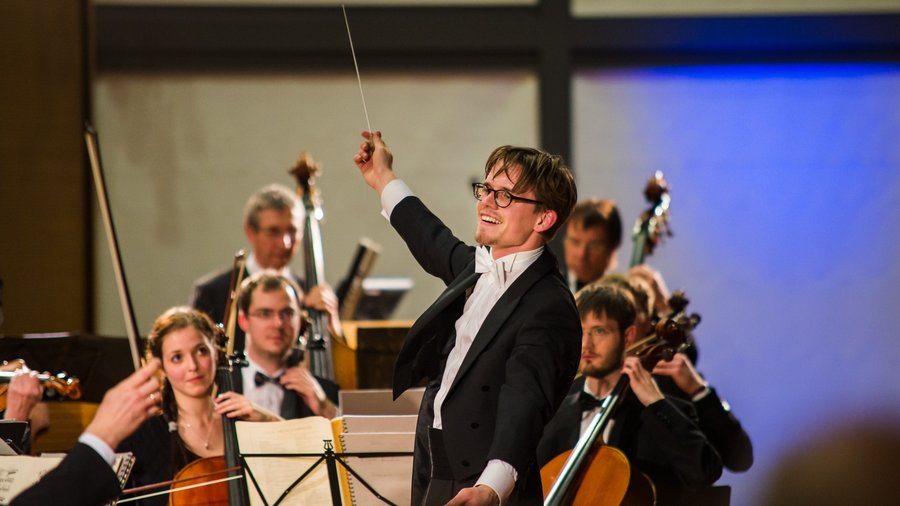 Mann dirigiert Orchester