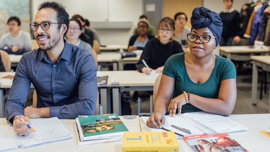 Studiernden aus verschiedenen Nationen sitzen in Seminarraum und lernen Deutsch.