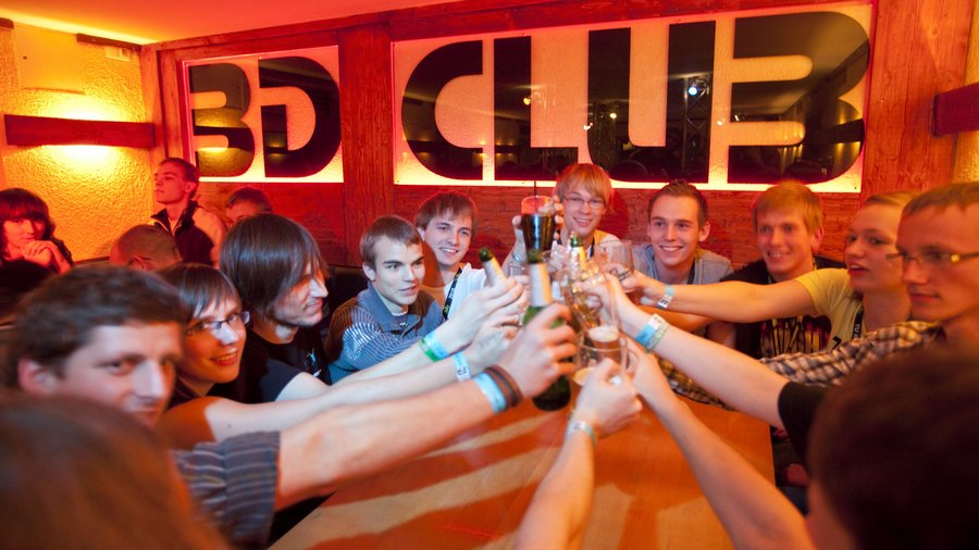 Junge Menschen prosten sich in Club mit Getränken zu