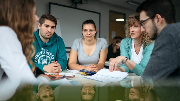 Studierende sitzen am Tisch