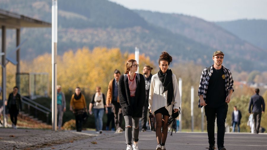 Studierende laufen über den herbstlichen Campus der TU Ilmenau 