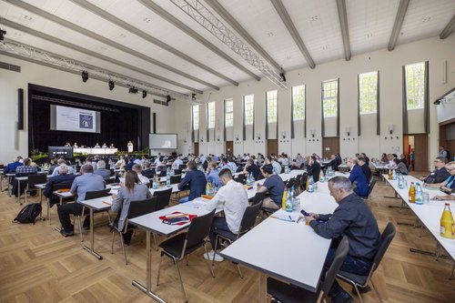Besucher*innen an Konferenztischen