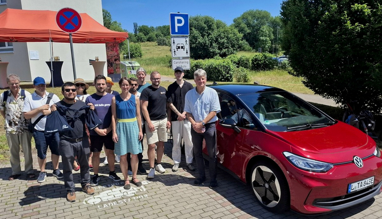 Mehrere Menschen neben einem Elektroauto