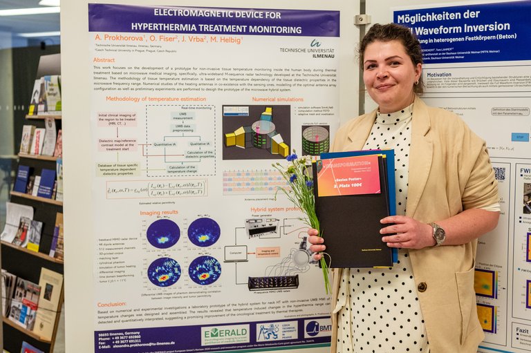 Young woman with certificate and flowers standing in front of a scientific poster