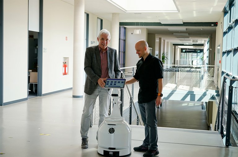 Prof. Groß und Mitarbeiter am Roboter
